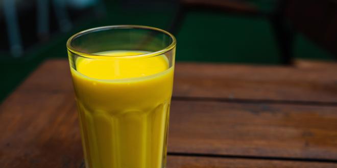 a tall glass of a creamy mango smoothie
